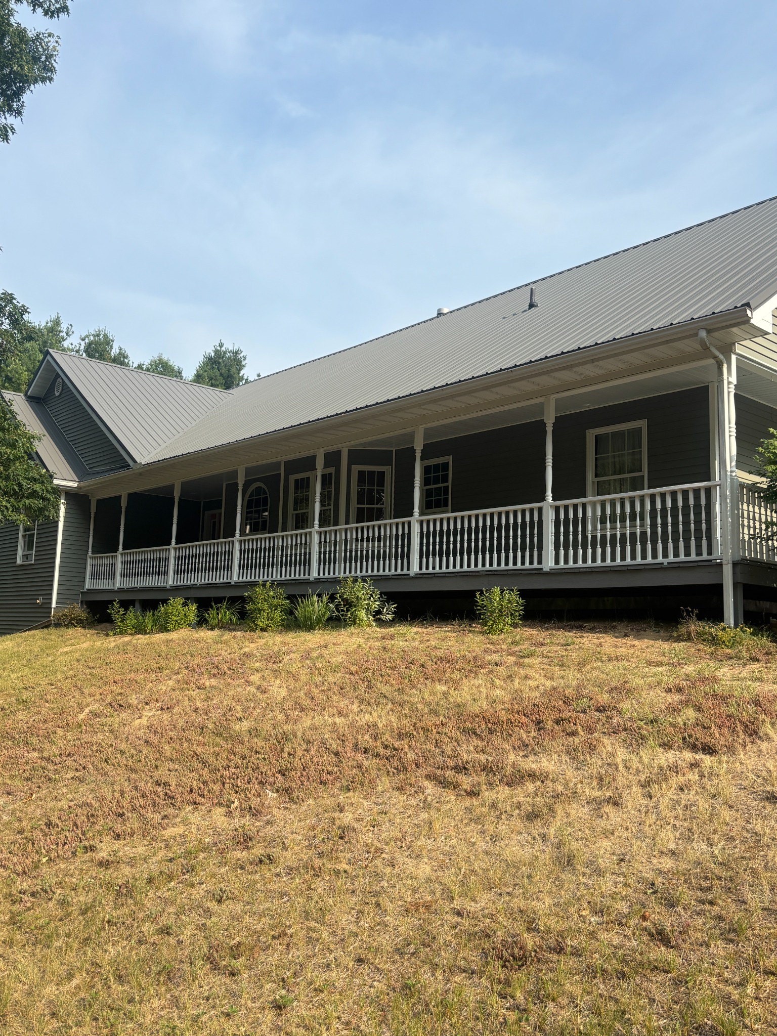 Finished dark home exterior with long white porch railing